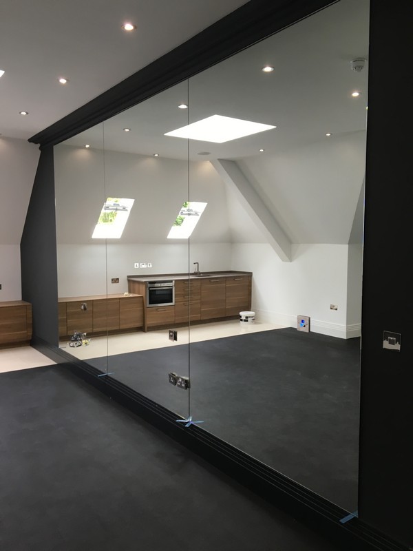 Frameless glass partition in loft conversion by Golders Green glaziers