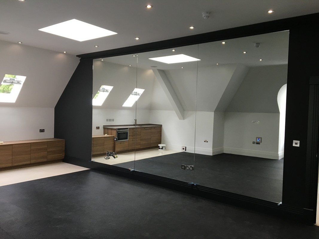 Frameless glass wall dividing loft conversion in Golders Green
